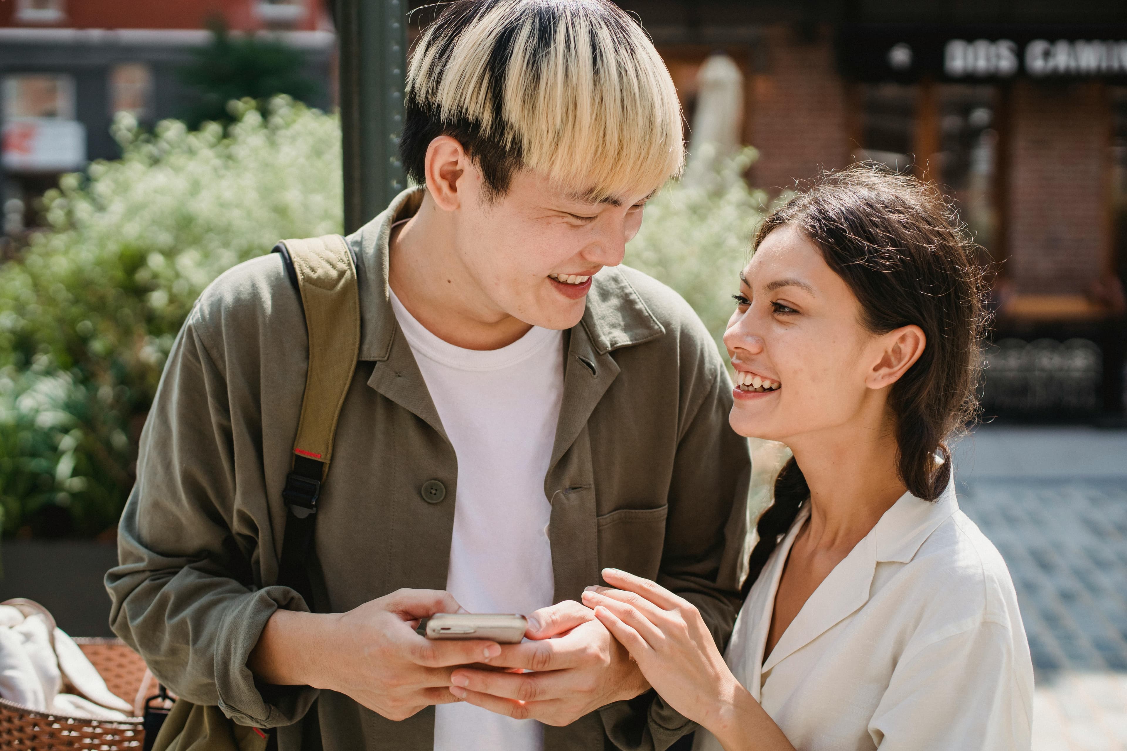Young man woman laughing holding phone